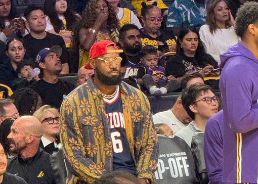 Ảnh của Meji: LeBron đang mặc đồng phục đại học của cậu con trai út Bryce và xem trận đấu từ bên lề